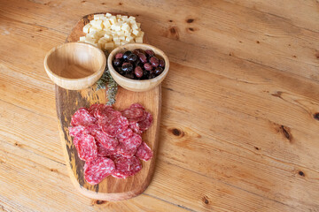 chorizo, ​​cheese and olives on wooden board