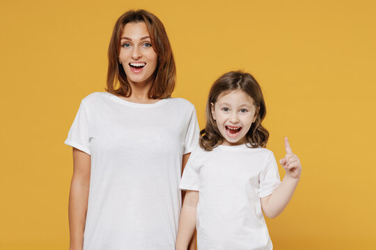 Happy Woman In Basic White Tshirt Have Fun With Child Baby Girl 5-6 Years Old Raised Finger Up Idea Mom Little Kid Daughter Isolated On Yellow Color Background Studio Mother's Day Love Family Concept