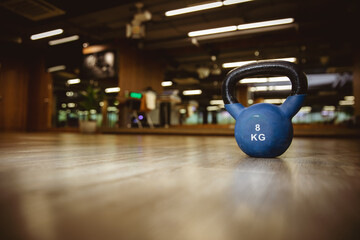 Naklejka na ściany i meble Blue kettle bell on wooden floor in gym