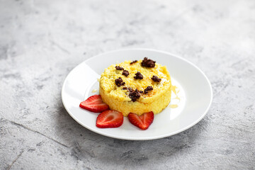 Millet porridge with strawberries on a concrete background