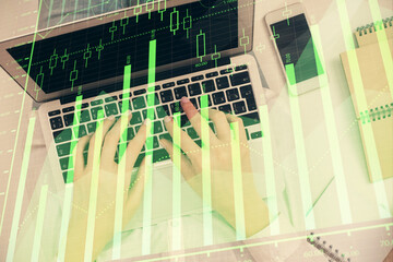 Obraz premium Double exposure of woman hands working on computer and forex chart hologram drawing. Top View. Financial analysis concept.