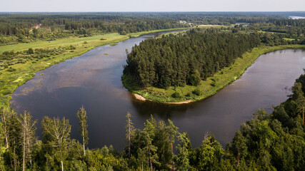 Aerial view of beautiful river bend and forests on a sunny summer day. 