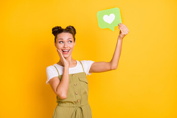 Portrait of attractive trendy amazed cheerful girl holding in hand paper card heart like isolated...