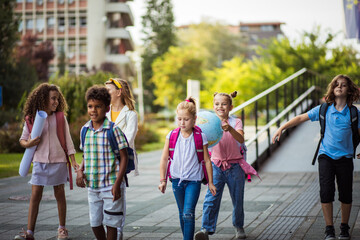 School kids walking in schoolyard.