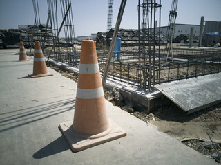 Orange traffic cones is setup around construction site for safety work, photo is dark style
