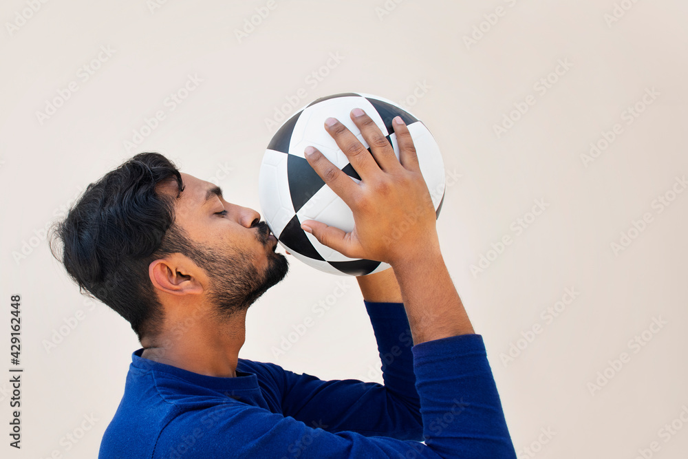 Wall mural  Indian Football player kissing soccer ball