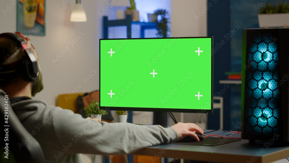 Poster pro gamer streaming video games with green screen mock-up display in gaming home studio. player usin