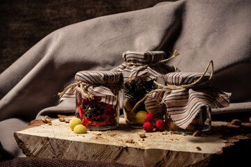 Jars of drying and candy stand on a wooden board on a brown background