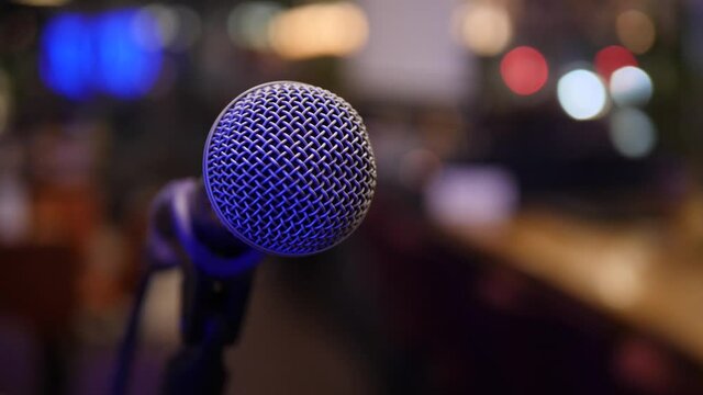 Concert microphone on the stage on blurred lights close up