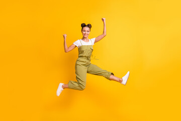 Fototapeta na wymiar Full length body size view of attractive cheerful girl jumping rejoicing having fun isolated over bright yellow color background