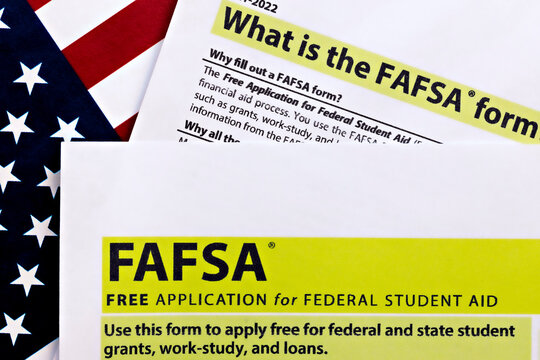 topview photo of FAFSA - free application for federal student aid, on a background of United States flag.
