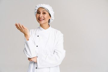 Asian mature woman in white chef uniform smiling at camera
