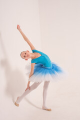 Ballerina in a ballet tutu and pointe shoes. The child ballerina is dancing. Girl on isolate