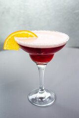 red cocktail with orange on a gray background