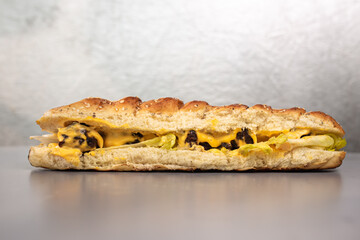 bun with cheese and meat on a gray background. Fast food