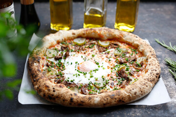 Pizza with egg, pulley pork, pickles and cheese.
Culinary photography. Proposal for dishes.