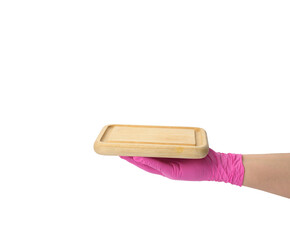 hand in pink latex glove holding rectangular cutting board on white isolated background