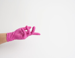 female hand in a pink latex glove on a white background, palm open