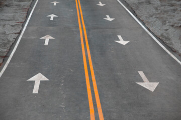 Asphalt Road with Two Yellow Dividing Lanes and Arrows Drawn on the Asphalt Indicating The Direction of Movement. Concept of Traffic Rules, Motivation, Business