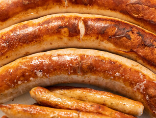 Bratwurst gebraten in der Pfanne in einer Nahaufnahme