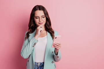 Photo of pensive minded smart lady hold phone think finger chin posing on pink background