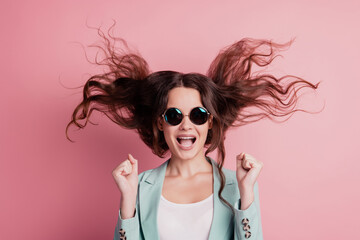 Joyful excited surprised young woman with flying hair raise fists rejoicing scream