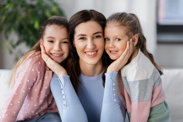 people, family and love concept - happy smiling mother with two daughters at home