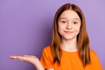 Portrait of attractive cheery cute girl holding on palm copy empty blank space isolated over violet purple color background