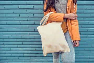 Girl holding a bag in front of a wall