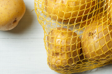 Fresh unpeeled potatoes in the grid. Natural background with vegetables. Close up, with copy space