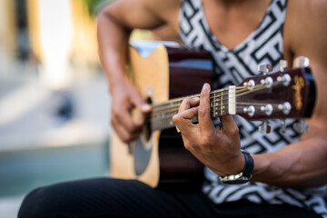 Detail of latin guitar player playing guitar in the street