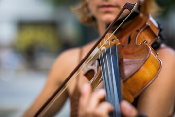 Fototapeta premium Detail of unrecognizable red-haired violinist playing the violin in the street