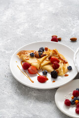 Summer berries breakfast french crepes on light surface