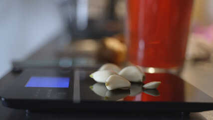Close-up of weighing several white gemstones. Using of black thin digital equipment to determine weight and value. Selective focus.