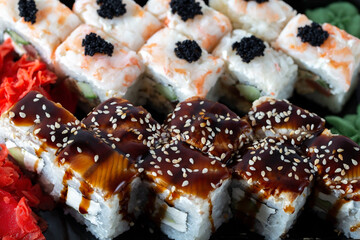 Rice square rolls with shrimp meat, eel, vegetables, creamy white cheese and sauces close-up