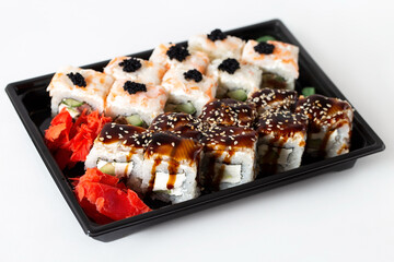 Delivery of Asian food in a plastic container. Rice rolls with shrimp meat, eel and creamy white cheese garnished with sauces