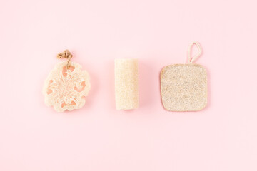 Natural hygiene products, wooden anti cellulite massager, loofah sponge, eco friendly, zero waste. Reusable items for beauty treatment from organic biodegradable material on pink backdrop.