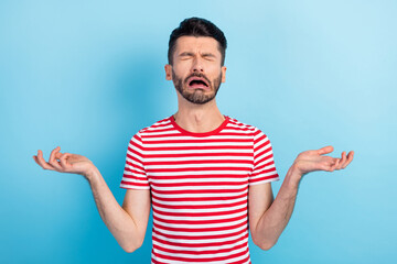 Photo of sad young man raise hands frustrated problem cry tears isolated on pastel blue color background