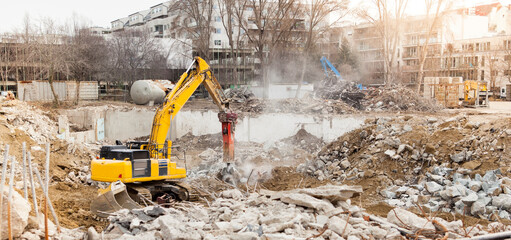 Excavator crusher machine at demolition on construction site. Bagger-Maschine beim Abriss auf der...