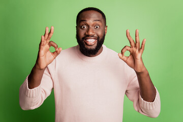 Photo of amazed surprised man show two ok signs wear white shirt over green background
