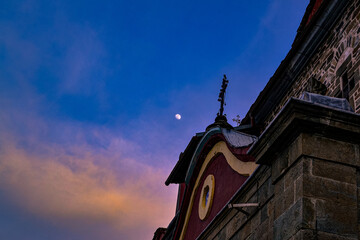 Fototapeta na wymiar Sunset meets Moon and Cross over Monastery