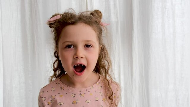 Curly blonde girl is surprised and looking at camera