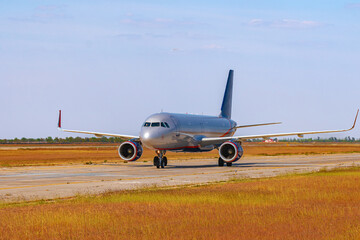 Big passenger airplane drives along the runway in airport