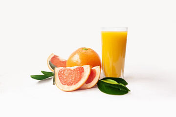 Grapefruit juice glass with whole grapefruit, slices and leaves isolated on white background. Fresh citrus fruit.