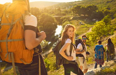 Smiling traveling woman with friends in mountains
