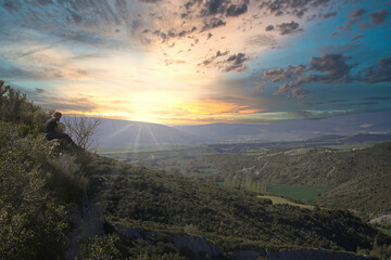 beautiful sunset in the mountains. a mountaineer observes the sky of a spectacular sunset in the mountains.