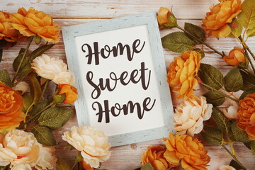 Home Sweet Home typography text with flower decoation on wooden background