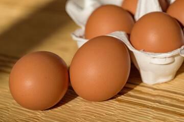 Chicken eggs in a paper carton, straw mat background