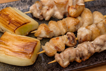 skewered chicken and green onions on a plate, Yakitori
