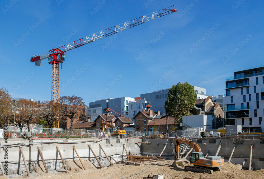 Wall mural Pelleteuse et grue sur un chantier de construction à Paris